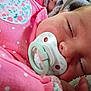 baby, blanket, child, close_up, cute, face, floral_pattern, hand, indoors, infant, newborn, pacifier, peaceful, pink_clothing, polka_dots, portrait, resting, sleeping, soft_texture, young