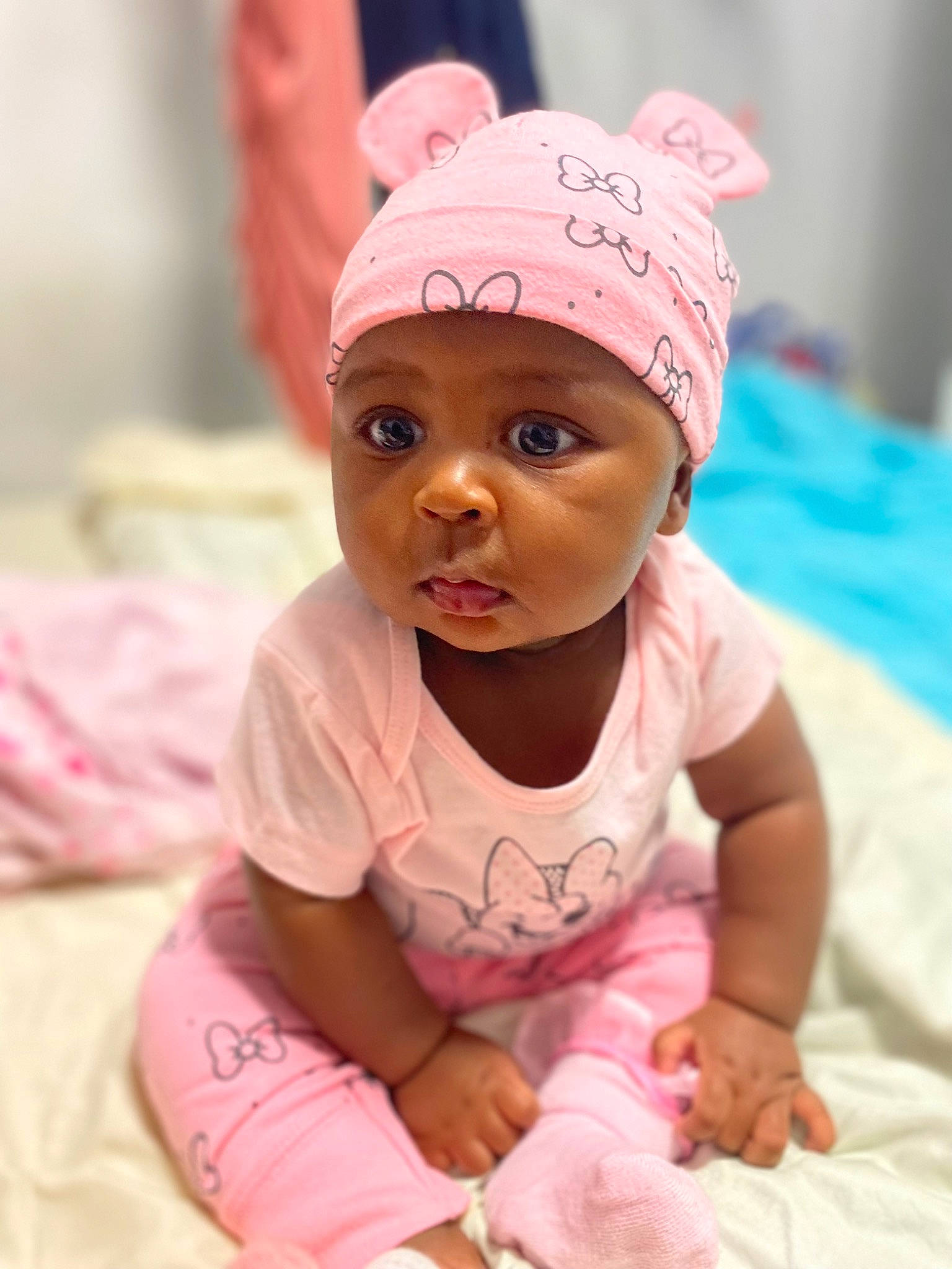 Tianna is registered to the contest to win money with this photo: baby, baby_toddler_clothing, cap, cheek, child, crawling, fun, happy, headgear, headwear, leisure, linens, magenta, person, pink, portrait_photography, room, sitting, skin, sleeve