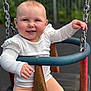 Olivia is registered to the contest to win money with this photo: baby, child, swing, playground, smiling, happy, outdoor, metal, chains, white_shirt, pink_leggings, cute, face, portrait, seated, fun, play, young, person, daylight
