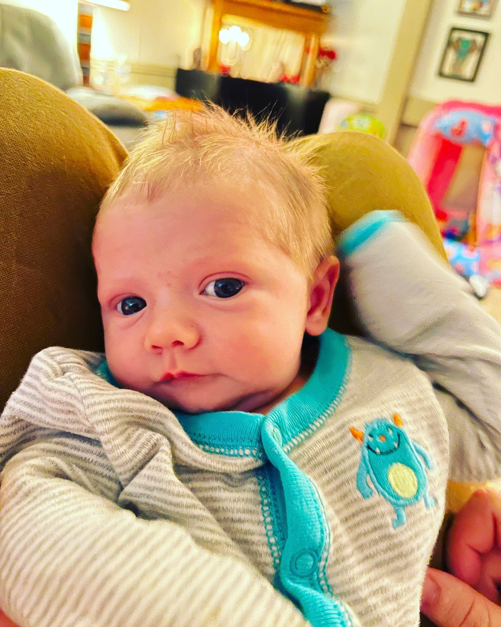 Granger is registered to the contest to win money with this photo: baby, baby_products, baby_safety, baby_toddler_clothing, bookcase, chair, cheek, child, comfort, fun, happy, iris, person, picture_frame, room, shelf, sitting, skin, sleeve, toddler