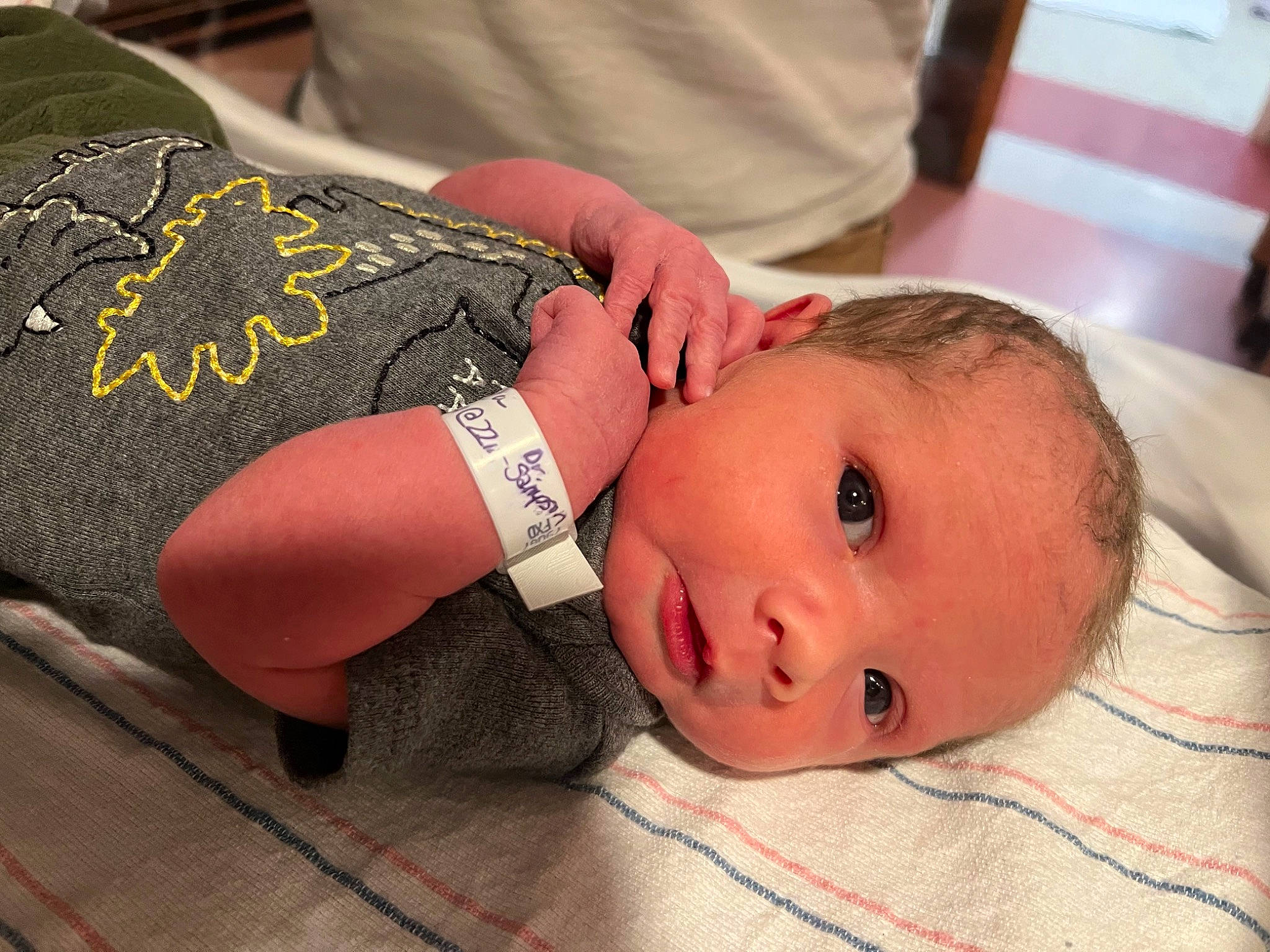 Granger is registered to the contest to win money with this photo: abdomen, baby, chest, comfort, elbow, eyelash, fashion_accessory, flooring, gesture, human_leg, nail, neck, pattern, person, skin, sleeve, thigh, thumb, toddler, wood