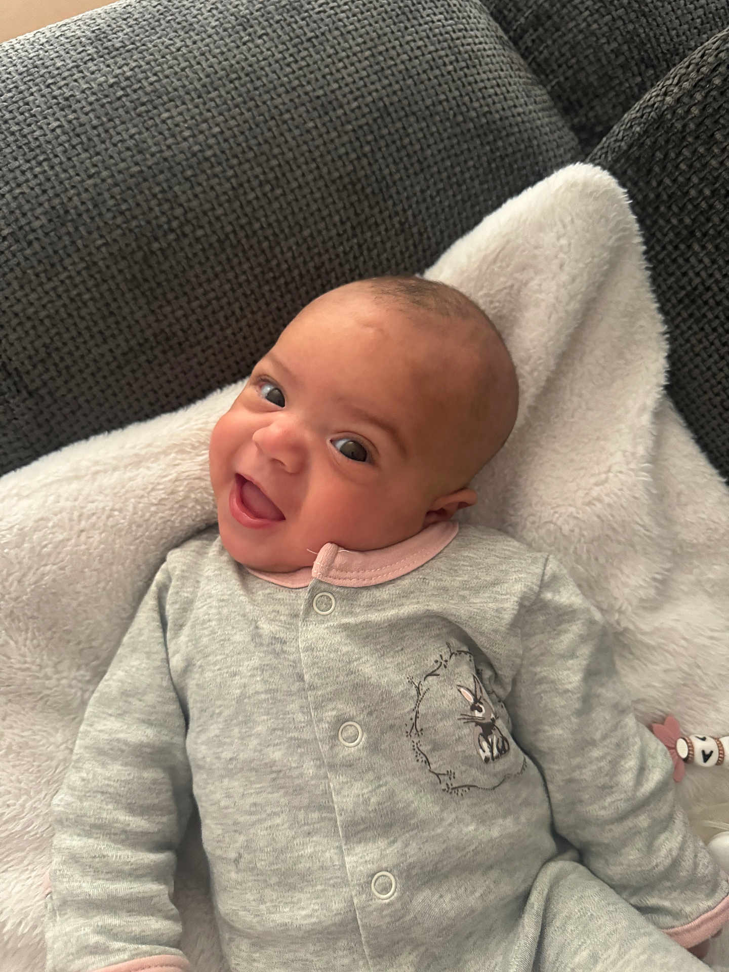 Thalia a rejoint le concours — aidez-le/la à gagner de superbes lots ! baby, infant, smile, onesie, blanket, couch, happy, face, human, child, indoor, cozy, cute, portrait, young, apparel, soft, expression, relaxing, comfort