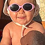 baby, child, sunglasses, hat, sunhat, doll, toy, smile, face, skin, arm, hand, outdoor, sunlight, shadow, clothing, texture, wall, person, happy