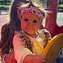 Léa a rejoint le concours — aidez-le/la à gagner de superbes lots ! butterfly_pattern, casual_clothing, child, curly_hair, daylight, happy, headband, long_hair, outdoor, park, person, play, playground, smile, sunlight, supporting_hand, toddler, trees, woman, yellow_steering_wheel