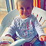 Léa participe au concours pour gagner de l'argent avec cette photo : toddler, child, smile, indoor, highchair, feeding, spoon, food, white_chair, pony_tail, long_sleeve_shirt, cute, happy, baby_food, face, person, window, curtain, blue_pants, safety_belt