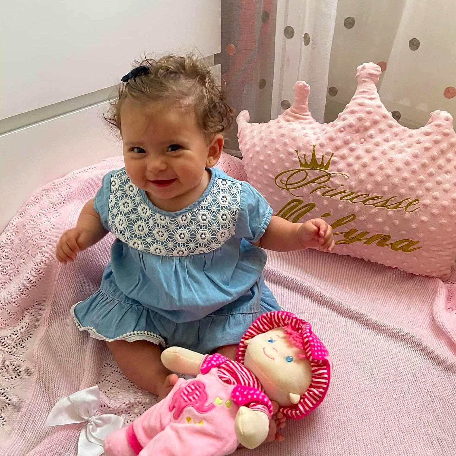 Mélyna participe au concours pour gagner de l'argent avec cette photo : arm, baby, baby_toddler_clothing, cheek, child, comfort, dress, eye, face, facial_expression, finger, happy, head, joy, person, photograph, pink, skin, sleeve, smile