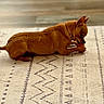 dog, small_dog, brown_dog, toy, chewing, collar, indoor, rug, patterned_rug, pet, animal, cute, focused, playing, floor, canine, domestic_animal, laying_down, side_view, household