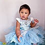 child, toddler, baby, princess_dress, blue_dress, tulle, sitting, portrait, indoor, white_wall, short_hair, brown_eyes, cute, hand, bare_feet, sparkle, fabric, glitter, photography, expression