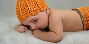 Nathaniel joined the competition — help win amazing prizes! baby, infant, child, knitted_hat, orange, lying_down, fluffy_surface, cute, soft_texture, skin, portrait, indoors, sleepwear, newborn, cozy, warm, small_hands, resting, headwear, peaceful
