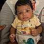 Messiah joined the competition — help win amazing prizes! baby, infant, child, toddler, face, hands, yellow_shirt, animal_print, turtle, dogs, baby_seat, clothing, indoor, person, curly_hair, cute, expression, support_hand, soft_lighting, comfort