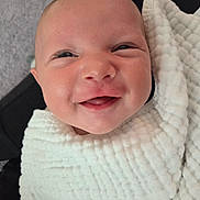 Tyson is registered to the contest to win money with this photo: baby, smiling, blanket, infant, face, happy, wrapped, cute, person, indoors, newborn, skin, head, expression, portrait, cozy, human, child, closeup, warm