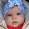 baby, child, face, headband, blue_eyes, jacket, red_sweater, cute, portrait, close_up, warm_clothing, infant, outdoor, expression, headwear, bow, soft_texture, skin, young_child, winter