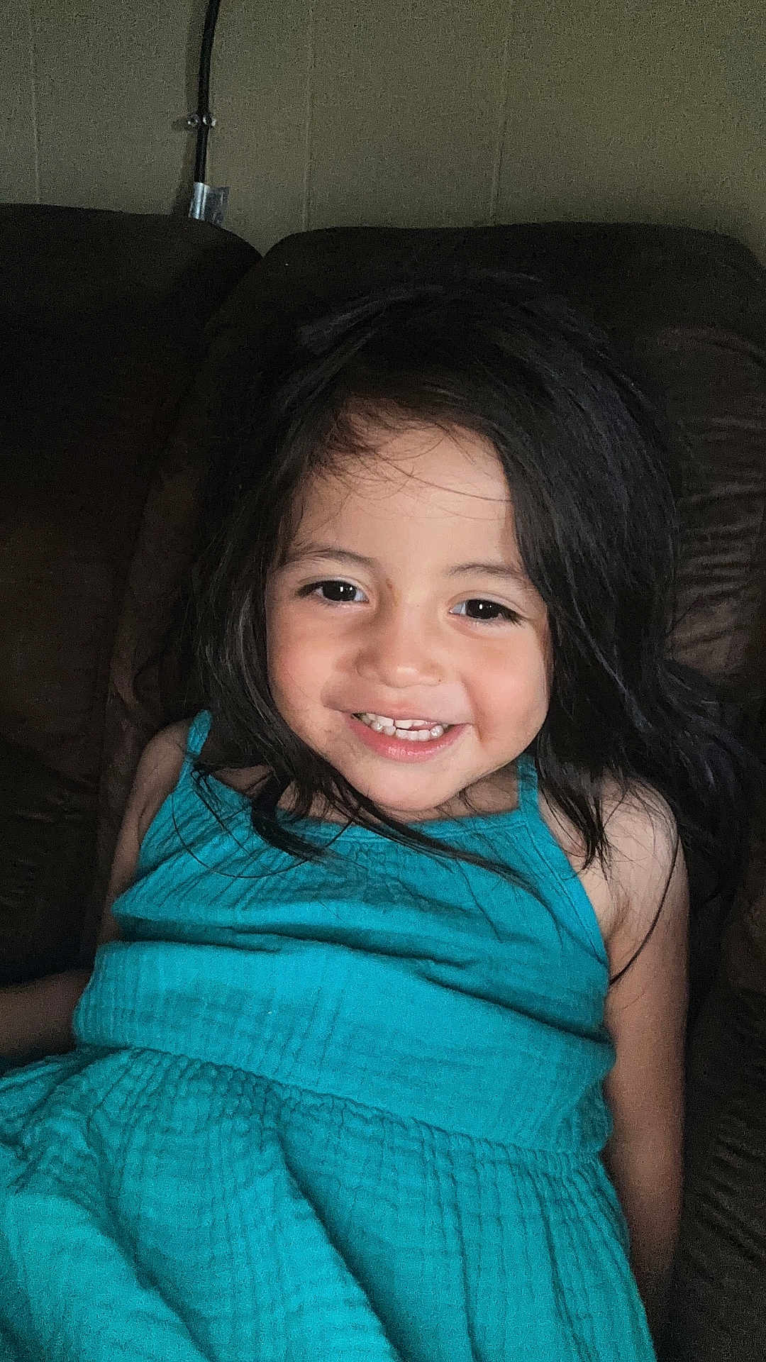 Eliannah is registered to the contest to win money with this photo: bodypart, child, clothing, couch, cushion, dress, face, female, furniture, girl, happy, head, homedecor, laughing, mouth, person, photography, portrait, smile, teeth