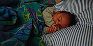 Xavier joined the competition — help win amazing prizes! baby, sleeping, blanket, peace_sign, striped_pillow, infant, child, rest, cute, face, hand, cozy, bed, comfort, relaxation, indoors, soft_fabric, toddler, peaceful, nap