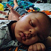 Xavier is registered to the contest to win money with this photo: baby, sleeping, child, face, hand, blanket, clothing, cute, cozy, infant, chubby_cheeks, resting, indoors, person, bed, soft, peaceful, animal_print, toddler, portrait