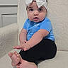 baby, child, infant, bow, headband, blue_shirt, black_pants, bare_feet, sitting, portrait, indoors, chair, cushion, wall, door, wide_eyed, curious, cute, fashion, foot