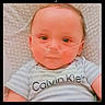 baby, infant, nasal_cannula, striped_shirt, calvin_klein, blanket, closeup, face, portrait, lying_down, child, medical_device, cute, indoors, young, person, head, expression, eyes, soft_lighting