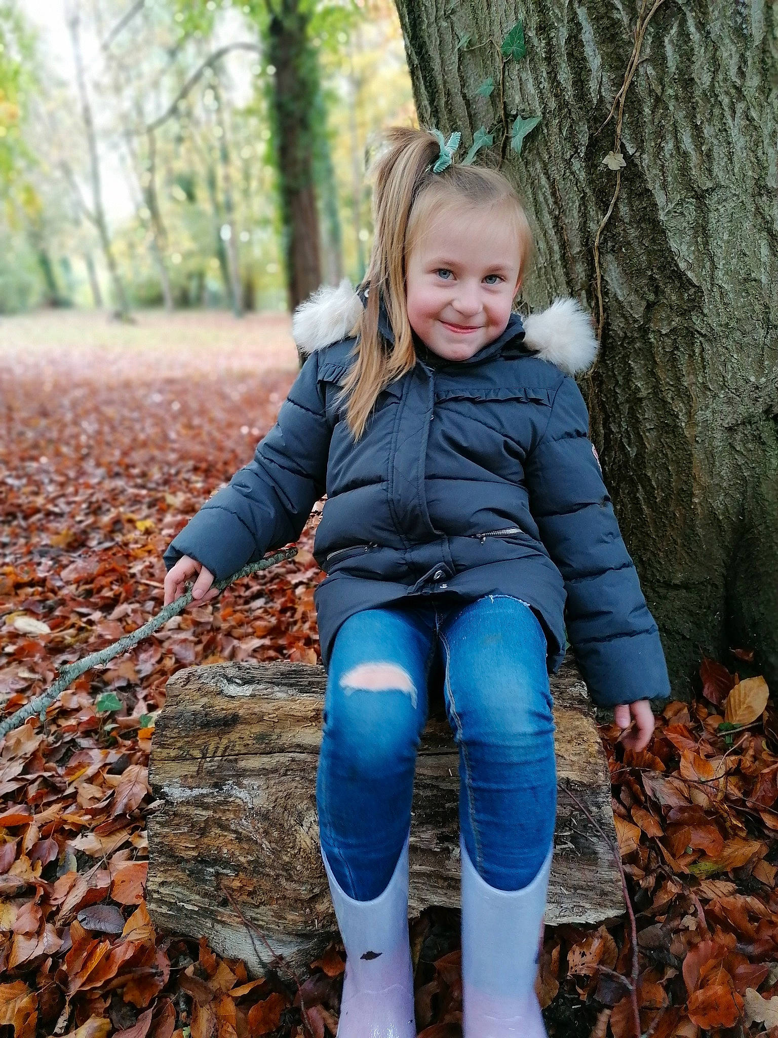 Louise participe au concours pour gagner de l'argent avec cette photo : autumn, beauty, blond, boot, deciduous, denim, electric_blue, eye, forest, jacket, jeans, joy, leaf, long_hair, people_in_nature, person, sitting, textile, thigh, trunk
