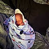 newborn, baby, blanket, cow_pattern, sleeping, cozy, plush, pillow, soft, wrapped, indoors, resting, child, cute, infant, peaceful, warm, fabric, comfort, portrait