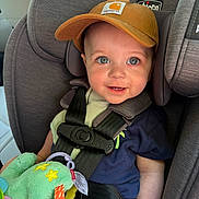 Colby joined the competition — help win amazing prizes! baby, child, car_seat, car, cap, plush_toy, toy, seatbelt, smiling, blue_eyes, clothing, infant, sitting, happy, cute, headwear, indoor, person, safety, portrait