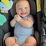 baby, infant, car_seat, smiling, happy, blue_eyes, plush_toy, clothing, onesie, cute, child, sitting, hands, feet, indoor, portrait, childcare, baby_toy, seatbelt, comfort