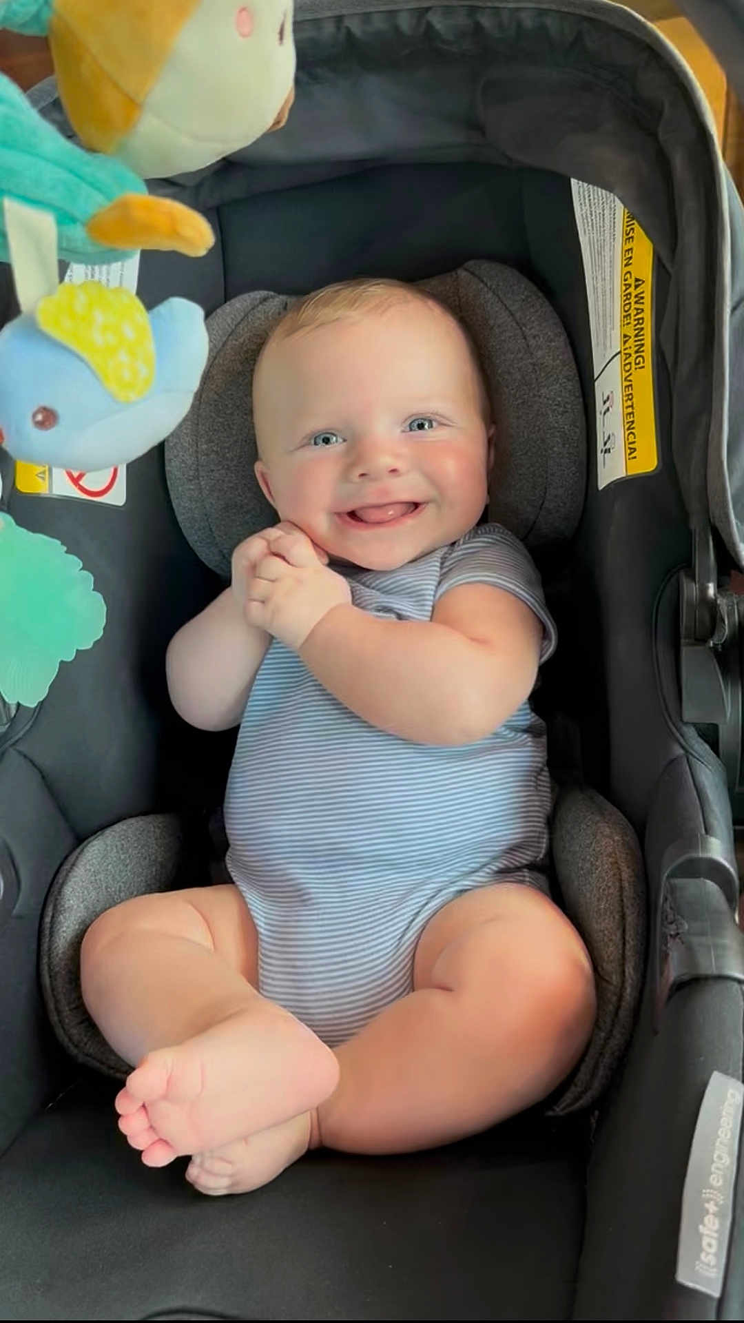 Jace joined the competition — help win amazing prizes! baby, infant, car_seat, smiling, happy, blue_eyes, plush_toy, clothing, onesie, cute, child, sitting, hands, feet, indoor, portrait, childcare, baby_toy, seatbelt, comfort