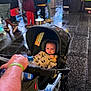 baby, blanket, canopy, child, city, curious, footwear, hand, infant, jacket, outdoor, pedestrian, people, person, rain, street, stroller, urban, walking, wet_pavement