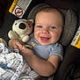 baby, smiling, blue_eyes, plush_toy, bear, blanket, car_seat, warning_label, infant, child, cute, happy, clothing, striped_shirt, indoor, portrait, holding, cuddly_toy, comfort, seat