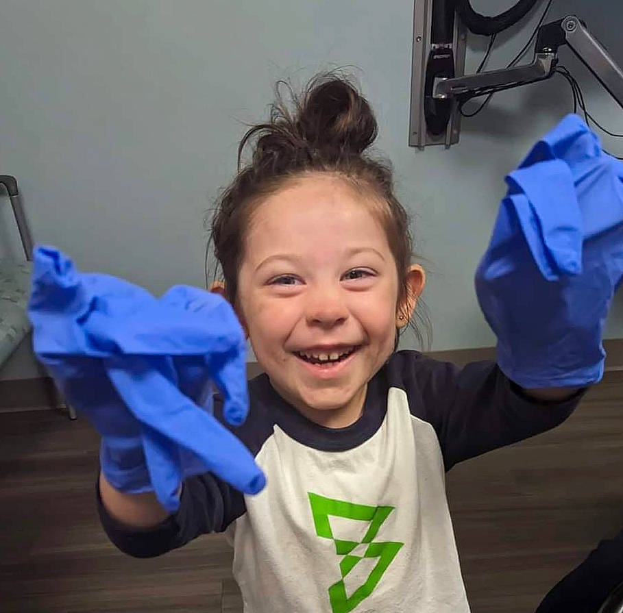 Victoria is registered to the contest to win money with this photo: child, clinic, electric_blue, finger, fun, gesture, glove, happy, health_care, hearing, joy, medical, medical_equipment, mouth, person, personal_protective_equipment, room, service, sleeve, smile