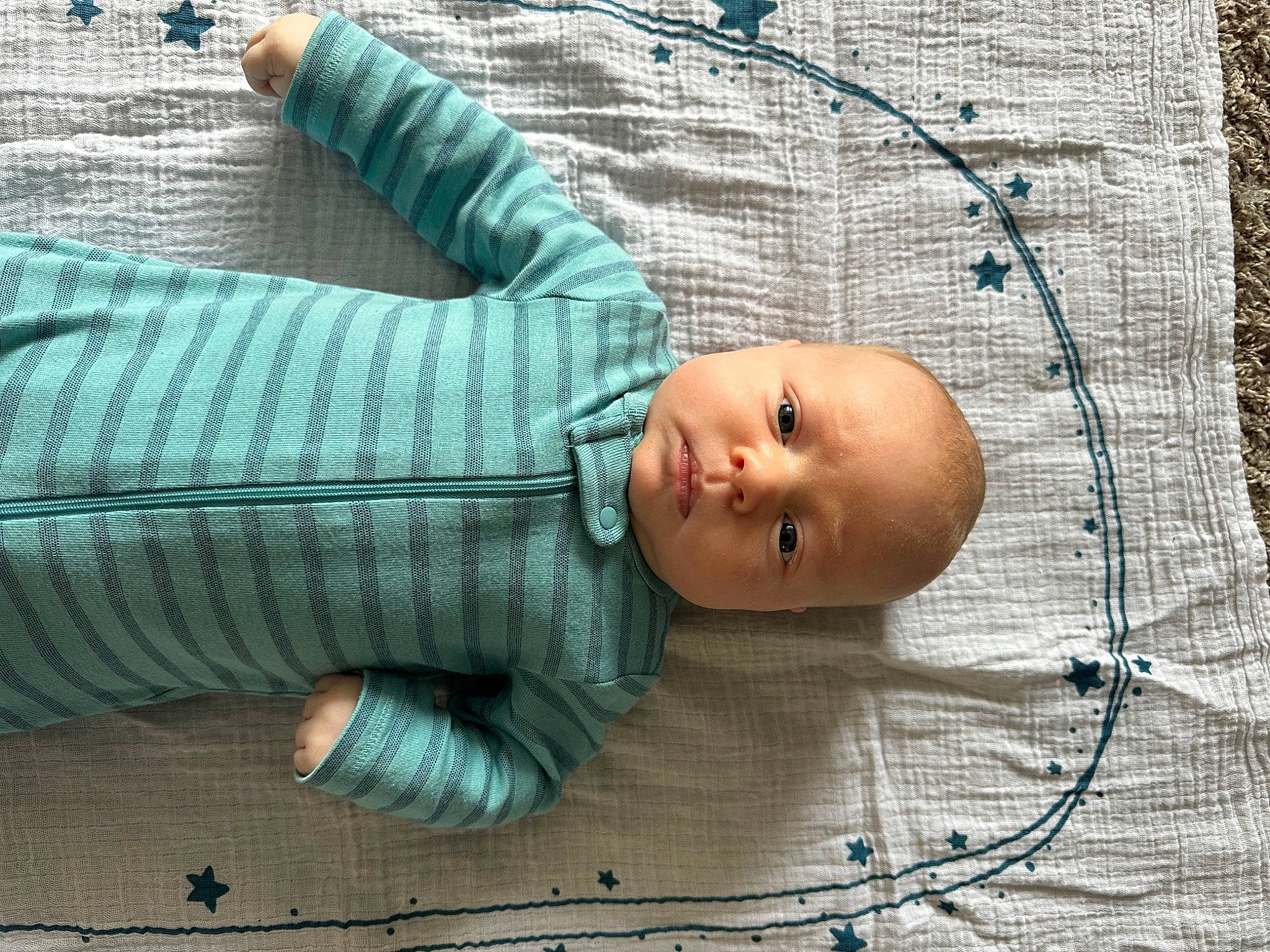 Ledger is registered to the contest to win money with this photo: baby, baby_products, baby_toddler_clothing, child, comfort, face, hand, head, human_body, knitting, linens, pattern, person, product, sitting, skin, textile, toddler, tree, wood