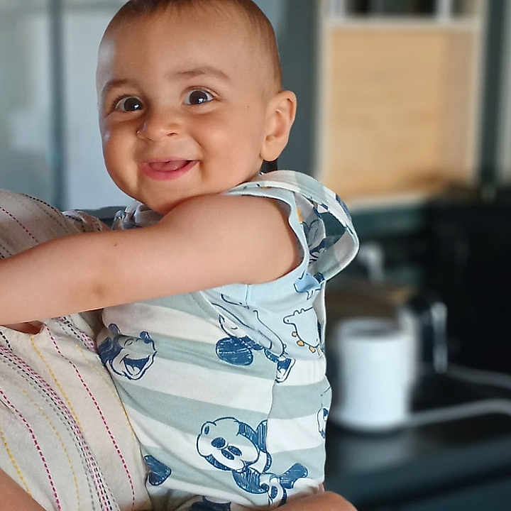 Noham a rejoint le concours — aidez-le/la à gagner de superbes lots ! arms, baby, blurred_background, cartoon_print, child, cute, face, happy, head, holding, indoor, infant, light_skin, person, portrait, short_hair, smiling, striped_clothing, toddler, young_child