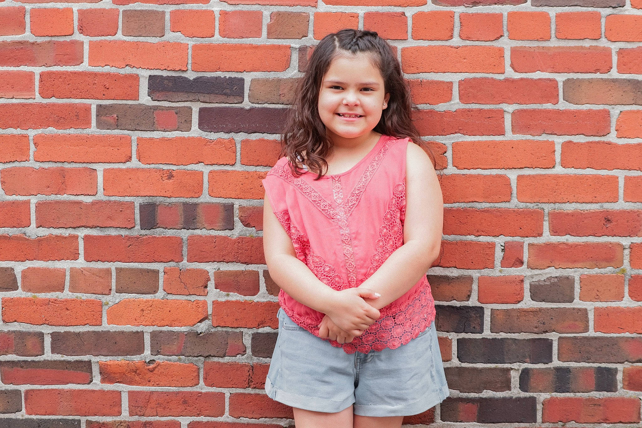 Mackenna joined the competition — help win amazing prizes! brick, brickwork, facial_expression, flash_photography, hairstyle, happy, joy, magenta, neck, orange, pattern, person, photograph, pink, red, shorts, sleeve, smile, standing, t_shirt