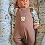 Taho participe au concours pour gagner de l'argent avec cette photo : baby, infant, onesie, bear_theme, cushion, patterned_bedding, animal_print, sleeping_area, soft_texture, child, cute, comfortable, resting, hand, footed_pajamas, face, portrait, indoors, cozy, gaze