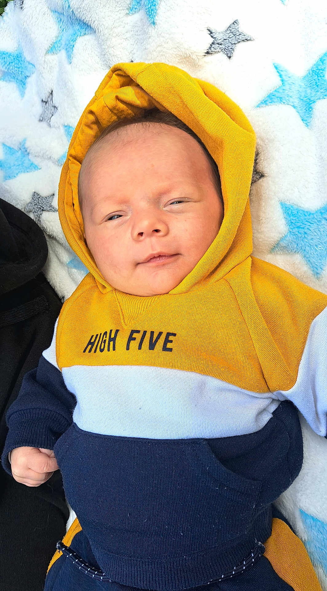 Taho a rejoint le concours — aidez-le/la à gagner de superbes lots ! baby, hoodie, yellow, blue, white, blanket, star_pattern, infant, clothing, cute, portrait, face, hand, casual, warm, soft, resting, smile, young_child, indoor