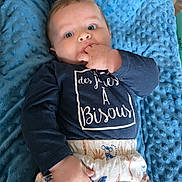 Lucien participe au concours pour gagner de l'argent avec cette photo : baby, infant, blue_blanket, navy_shirt, shorts, hand_in_mouth, lying_down, indoor, curious_expression, face, child, clothing, patterned_clothes, soft_texture, person, cute, small_child, light_skin, close_up, baby_boy