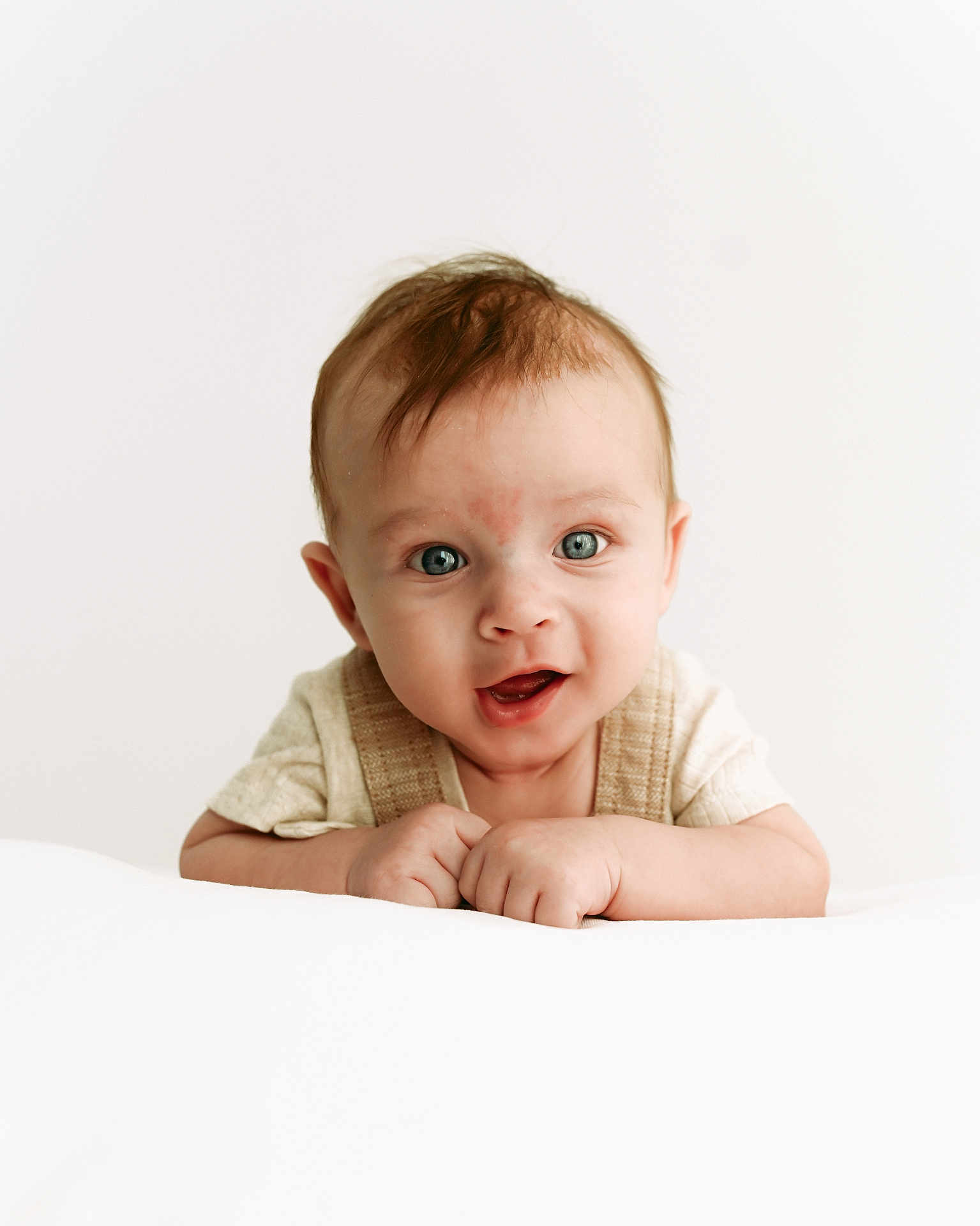 Erik is registered to the contest to win money with this photo: baby, infant, child, face, blue_eyes, smile, hands, curly_hair, cute, portrait, young_child, white_background, soft_lighting, closeup, expression, skin, clothing, front_view, happy, innocence