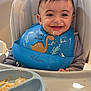 baby, bib, child, clothing, cute, dinosaur, face, feeding, food, happy, high_chair, indoor, infant, meal, messy, person, plate, smiling, tongue_out, young
