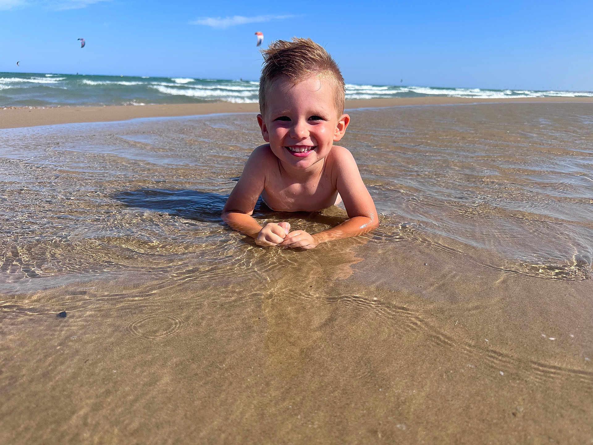 Giovanni participe au concours pour gagner de l'argent avec cette photo : child, boy, smiling, beach, water, ocean, sand, sunny, sky, waves, summer, fun, outdoor, happy, kitesurfing, play, nature, vacation, holiday, relaxation