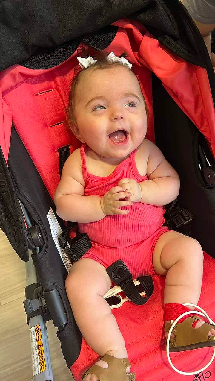 Andersyn joined the competition — help win amazing prizes! baby, baby_carriage, baby_products, baby_toddler_clothing, cheek, child, comfort, finger, hand, happy, lap, material_property, person, pink, red, skin, smile, thigh, thumb, toddler