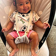 Cecelia is registered to the contest to win money with this photo: baby, infant, smiling, headband, pink, shirt, skull_print, shorts, baby_rocker, seat_belt, indoor, carpet, happy, cute, child, person, feet, hand, face, clothing