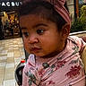 baby, child, clothing, curious, cute, expression, face, floral_shirt, hair, headband, holding, indoor, mall, person, pink, portrait, shopping_center, skin, toddler, young