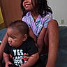 child, baby, indoor, bed, smile, dreadlocks, clothing, sitting, person, curious, black_shirt, purple_shirt, feet, sock, happy, cute, family, portrait, young, toddler