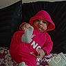 Lakendrick Jr. is registered to the contest to win money with this photo: baby, child, hoodie, red_clothing, sock, foot, pillow, cushion, blanket, floral_pattern, purse, indoor, person, cute, playful, portrait, sitting, expression, wall, fabric