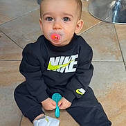 Heyden a rejoint le concours — aidez-le/la à gagner de superbes lots ! toddler, child, pacifier, black_clothing, nike_logo, sitting, indoor, tile_floor, white_shoes, blue_brush, curious_eyes, short_hair, casual, flooring, metal_chair_base, cute, young_child, fashion, comfort, baby