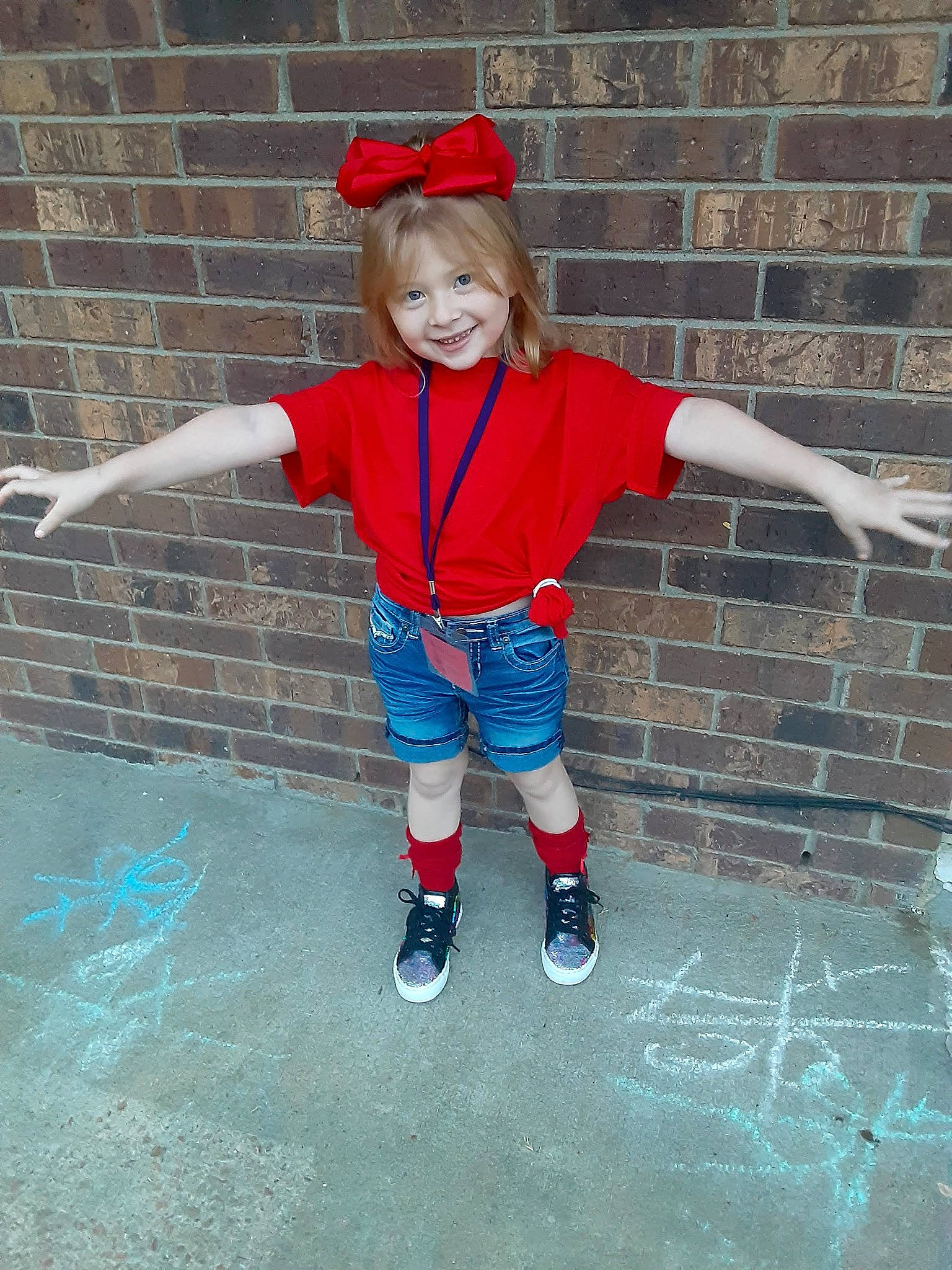 Kaycie is registered to the contest to win money with this photo: arm, boot, brick, brickwork, child, cool, electric_blue, face, fun, gesture, happy, human_leg, joint, joy, leisure, person, recreation, smile, sock, standing