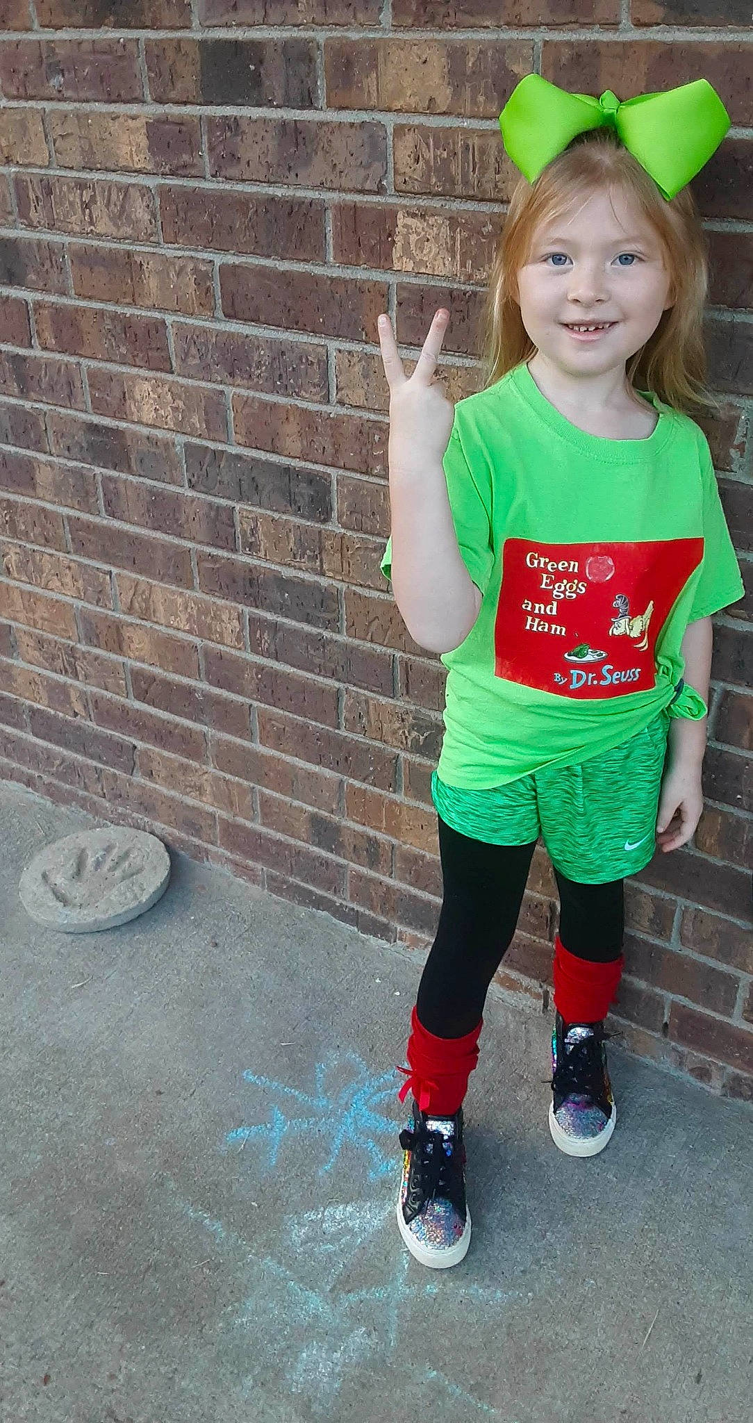 Kaycie is registered to the contest to win money with this photo: baby_toddler_clothing, brick, brickwork, cool, electric_blue, green, hair, happy, human_leg, joy, knee, outerwear, person, shorts, sleeve, smile, sportswear, street_fashion, t_shirt, thigh
