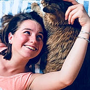 Mogwaï participe au concours pour gagner de l'argent avec cette photo : woman, cat, smiling, petting, bed, striped_bedspread, tabby_cat, indoor, bracelet, short_hair, happy, furniture, blue_wall, relaxing, friendship, comfort, person, cozy, resting, casual_clothing