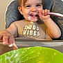 Aurora is registered to the contest to win money with this photo: toddler, child, high_chair, bib, spoon, food, smile, happy, messy, indoor, baby_food, face, feeding, person, plate, hand, table, closeup, cute, dining