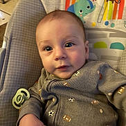 Issac joined the competition — help win amazing prizes! baby, infant, child, onesie, baby_seat, pacifier, cartoon, rainbow, elephant, monkey, indoor, cute, clothing, smiling, hand, person, face, toy, colorful, portrait