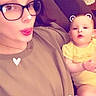Luna is registered to the contest to win money with this photo: woman, baby, glasses, face, couch, digital_filter, bear_ears, heart_shape, tongue_out, indoor, person, child, yellow_clothing, brown_hair, casual_wear, playful, cute, smiling, family, relaxing